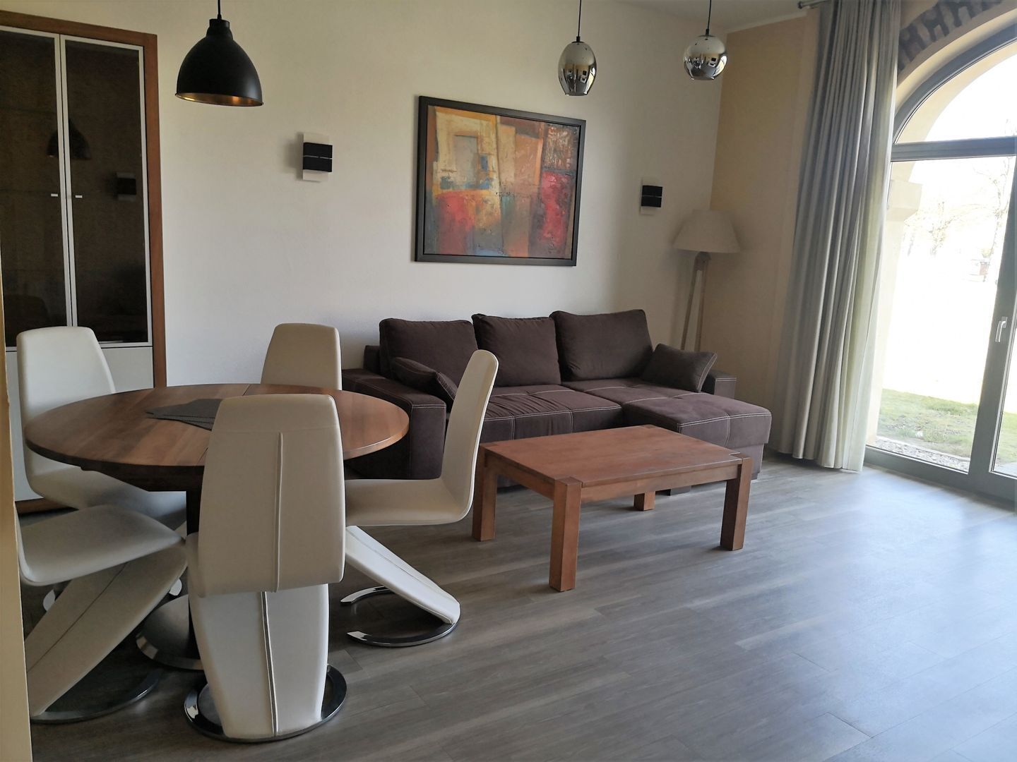 A modern living room with a round table, two sofas, and a coffee table.