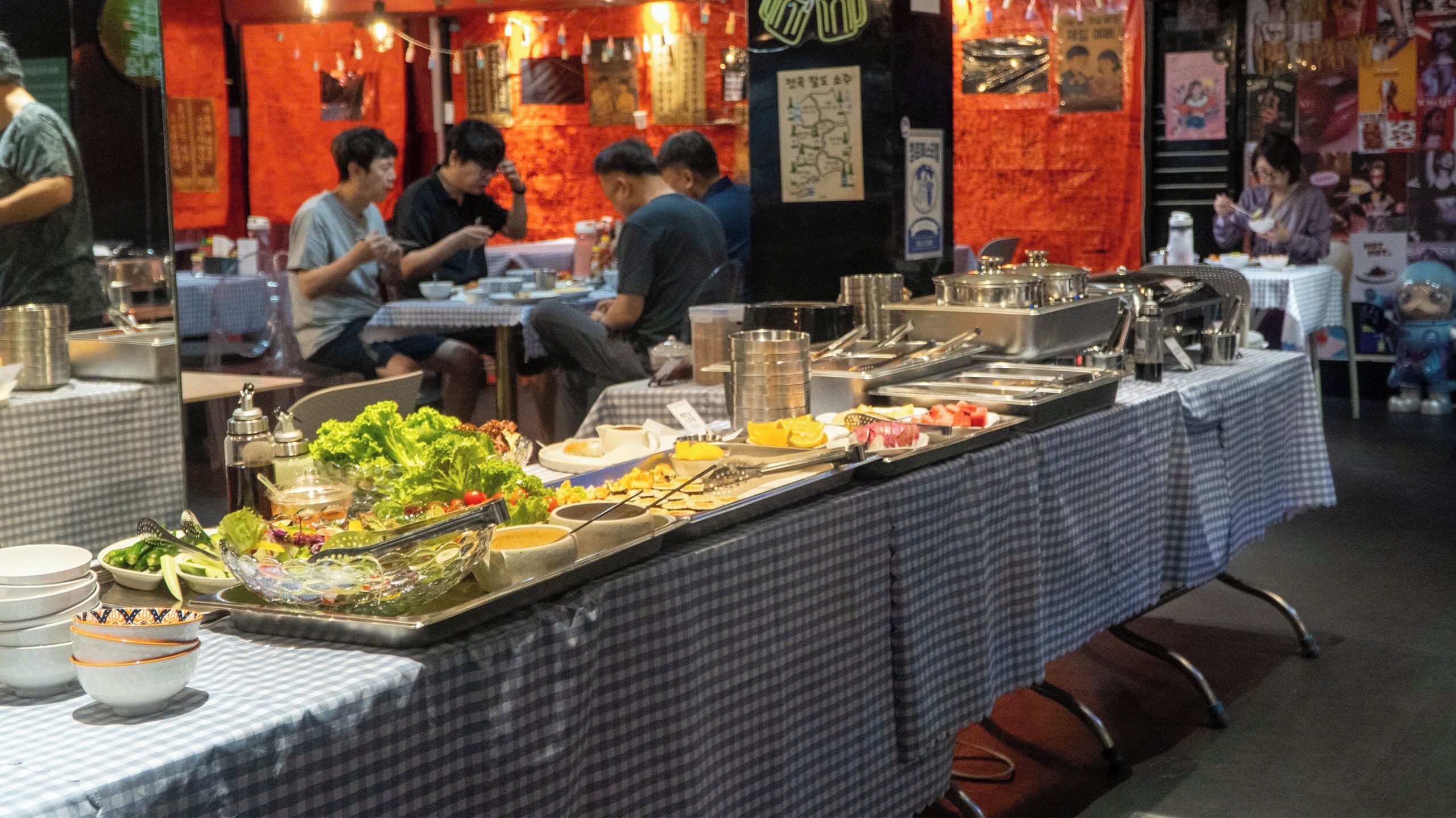 A buffet setup with various food items and utensils.