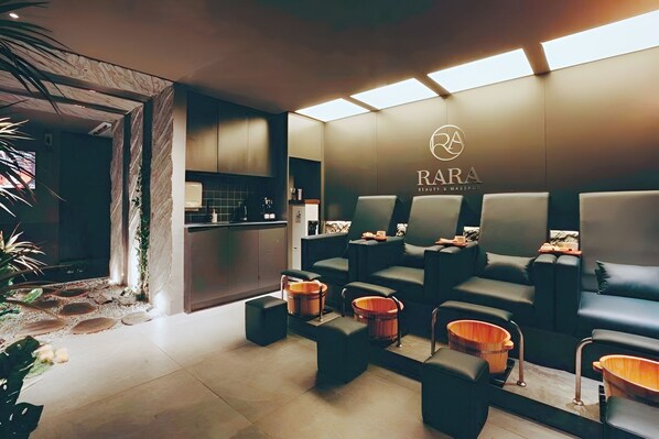 Un'area benessere con posti a sedere, una reception e un logo appeso al muro.
