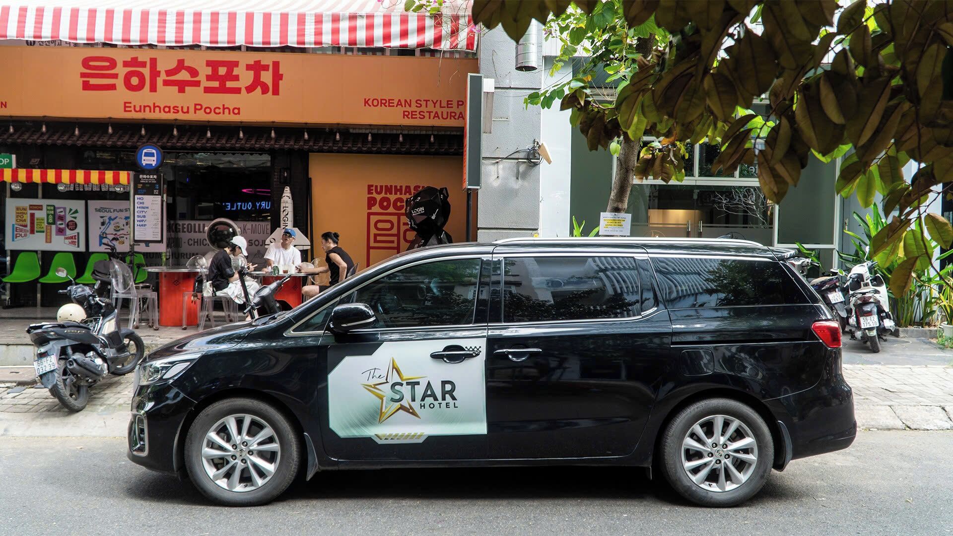 A black van with a 'Star Hotel' logo parked on the street.