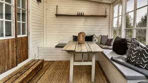 A cozy room with a wooden bench, a table, and a bench seat with cushions.