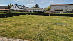 A residential area with houses, a well-maintained lawn, and parked cars. - Herold RE-01 - Cozy vacation apartment The Remise Herold on Usedom with (Stolpe auf Usedom)