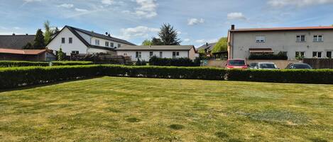 Un barrio residencial con casas, césped cuidado y coches aparcados.