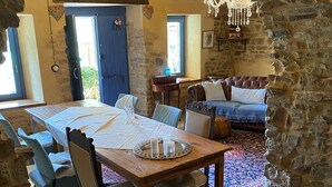 Un coin repas au style rustique, avec une table en bois, des chaises et un lustre.