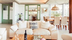 A modern living room with a sofa, coffee table, and dining area. - My Rental Homes - Villa Neper with private pool, terrace and covered parking (Sant Lluís)