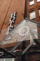 A hotel sign with a gear and the text "Hotel Am Fleh 1861".