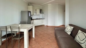 Un espacio habitable compacto con comedor, kitchenette y sofá.