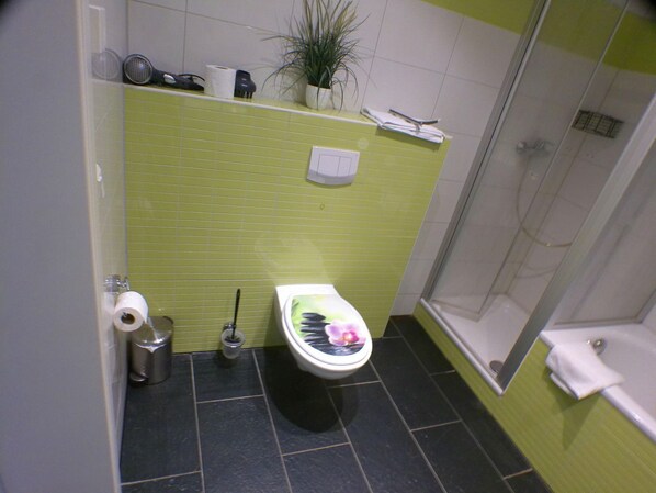 Un baño con inodoro, ducha y lavamanos.