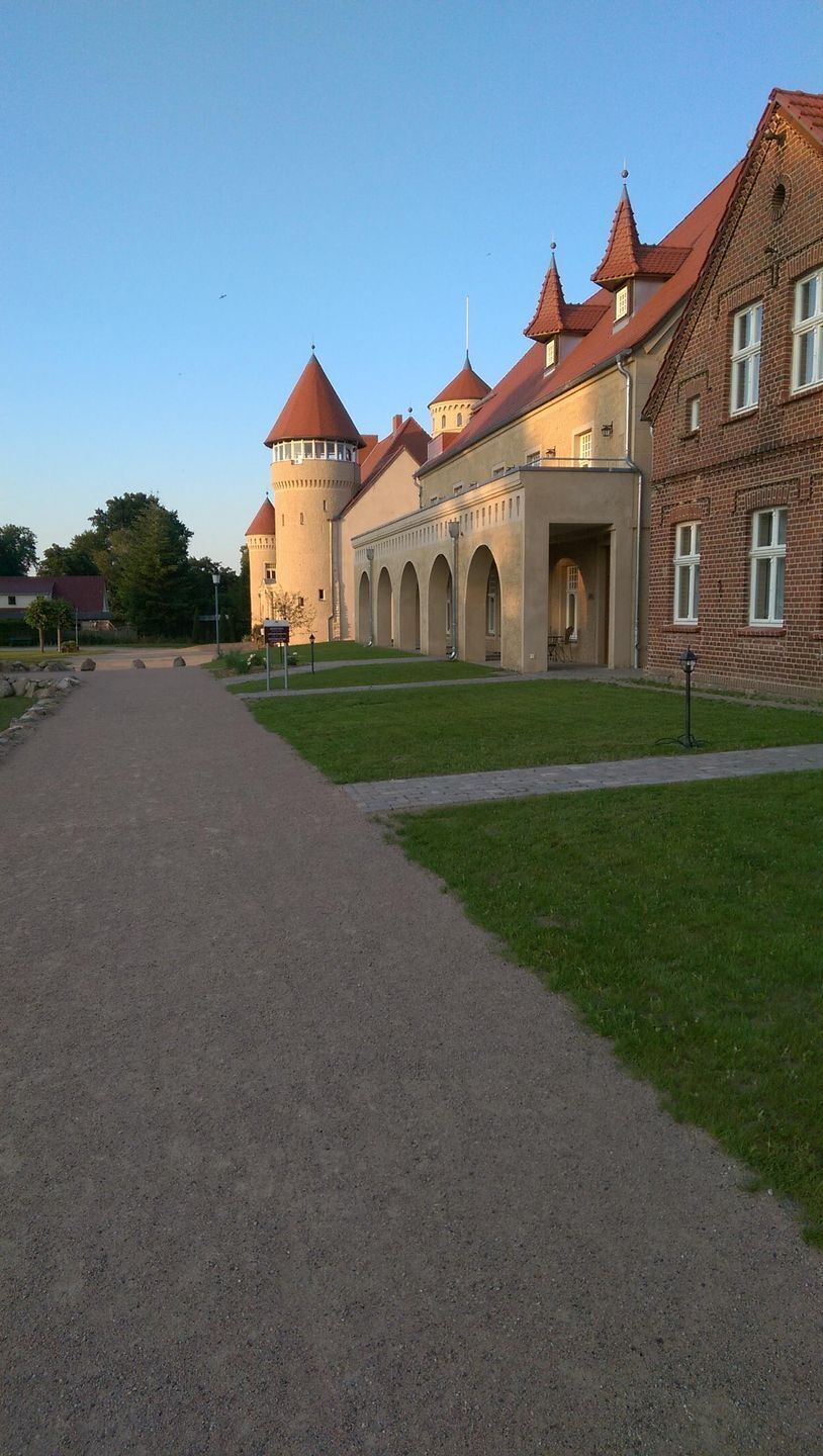 A historical building with a central courtyard, arched walkways, and red-tiled roofs.