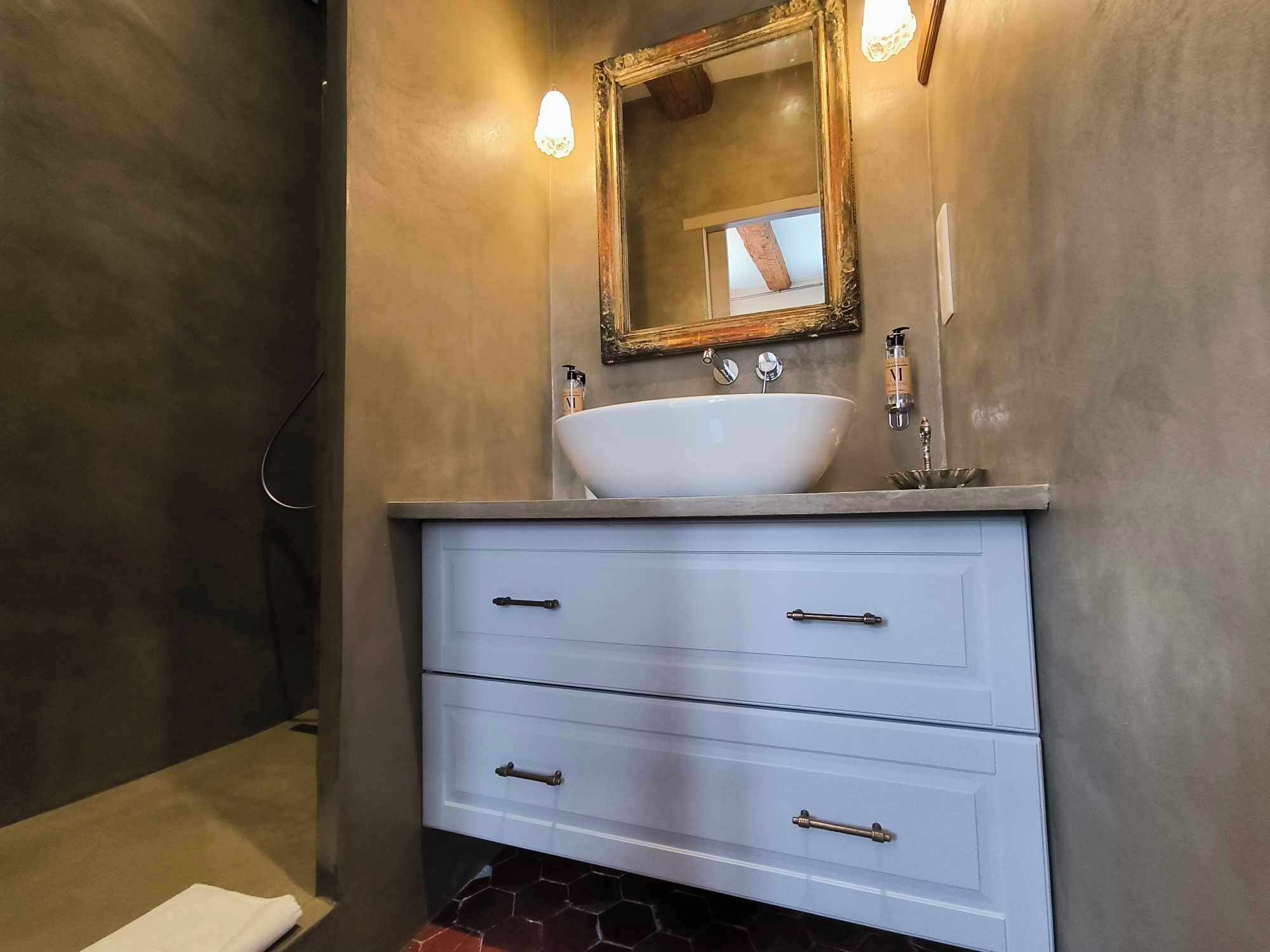 Un baño con un lavabo blanco, un espejo y una lámpara.