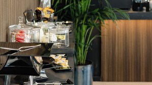 Ein reichhaltiges Buffet mit transparenten Glaskästen, Besteck und einem Blumentopf.