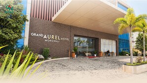 L’extérieur du Grand Aureel Hotel Morowali présente un design moderne, une entrée dallée et est entouré de verdure.