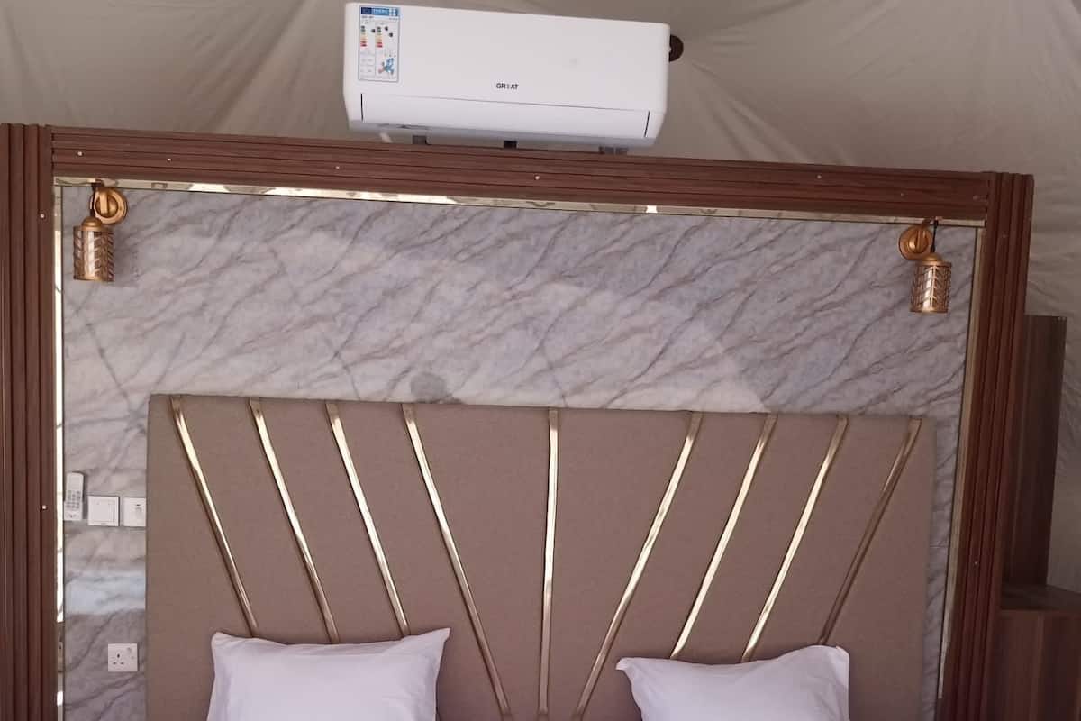Ein Bett mit Marmorkopfteil, zwei Kissen und einer weißen Decke.