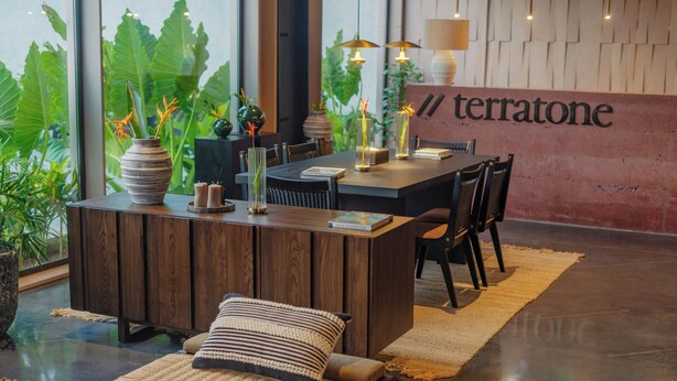 A modern dining area with a wooden table, chairs, and a central island with vases. - TERRATONE BOUTIQUE BUSINESS HOTEL (Kollam)