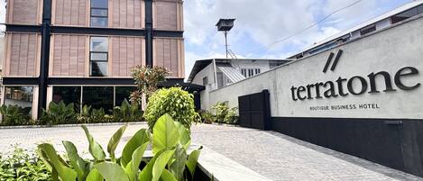 A modern building with a sign reading "Terratone Boutique Business Hotel".