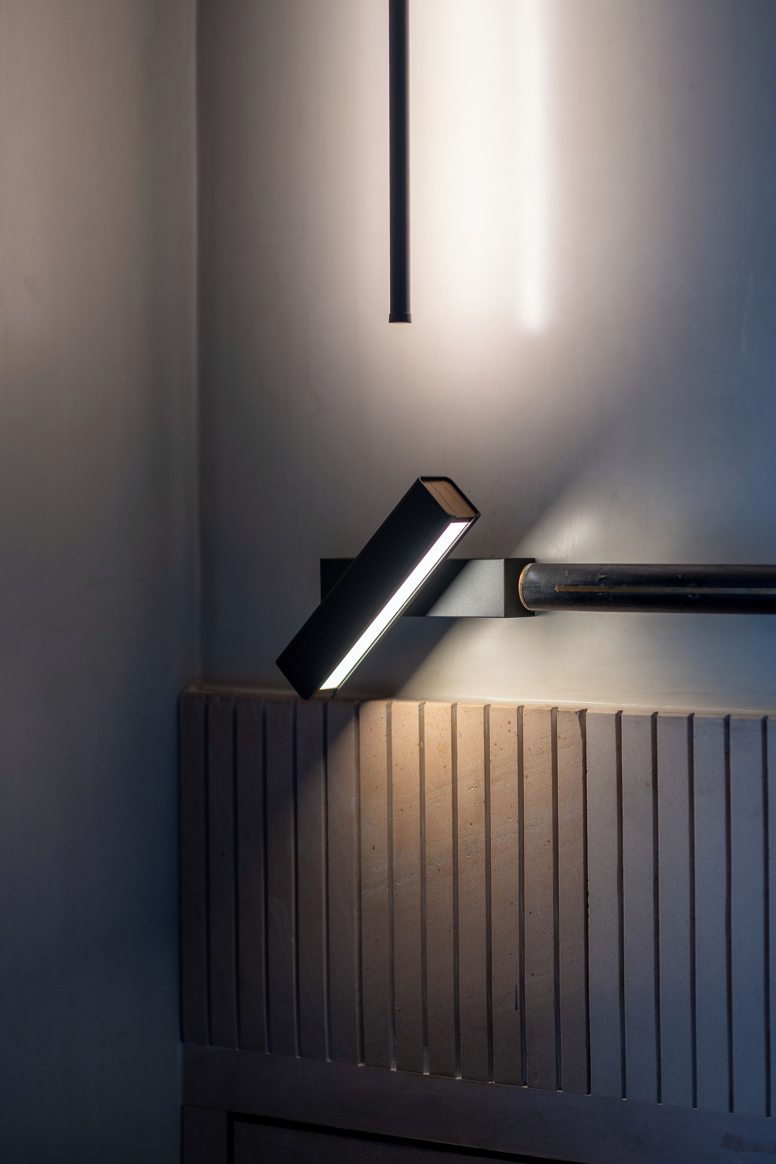 A modern bathroom with a sleek, illuminated mirror and a radiator.