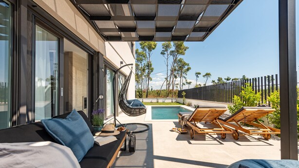 A modern outdoor living area with a sofa, lounge chairs, a pool, and a pergola. - Villa Cvita & Mia Zadarvillas (Privlaka)