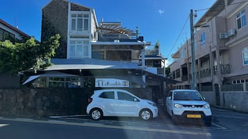 Un edificio con un letrero que dice "La Koquillishe B&B" y un coche blanco estacionado al frente.
