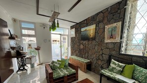 Un salon chaleureux avec un mur en pierre, des meubles en bois et un petit aquarium.