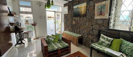 Uma sala de estar acolhedora com parede de pedra, móveis de madeira e um pequeno aquário.