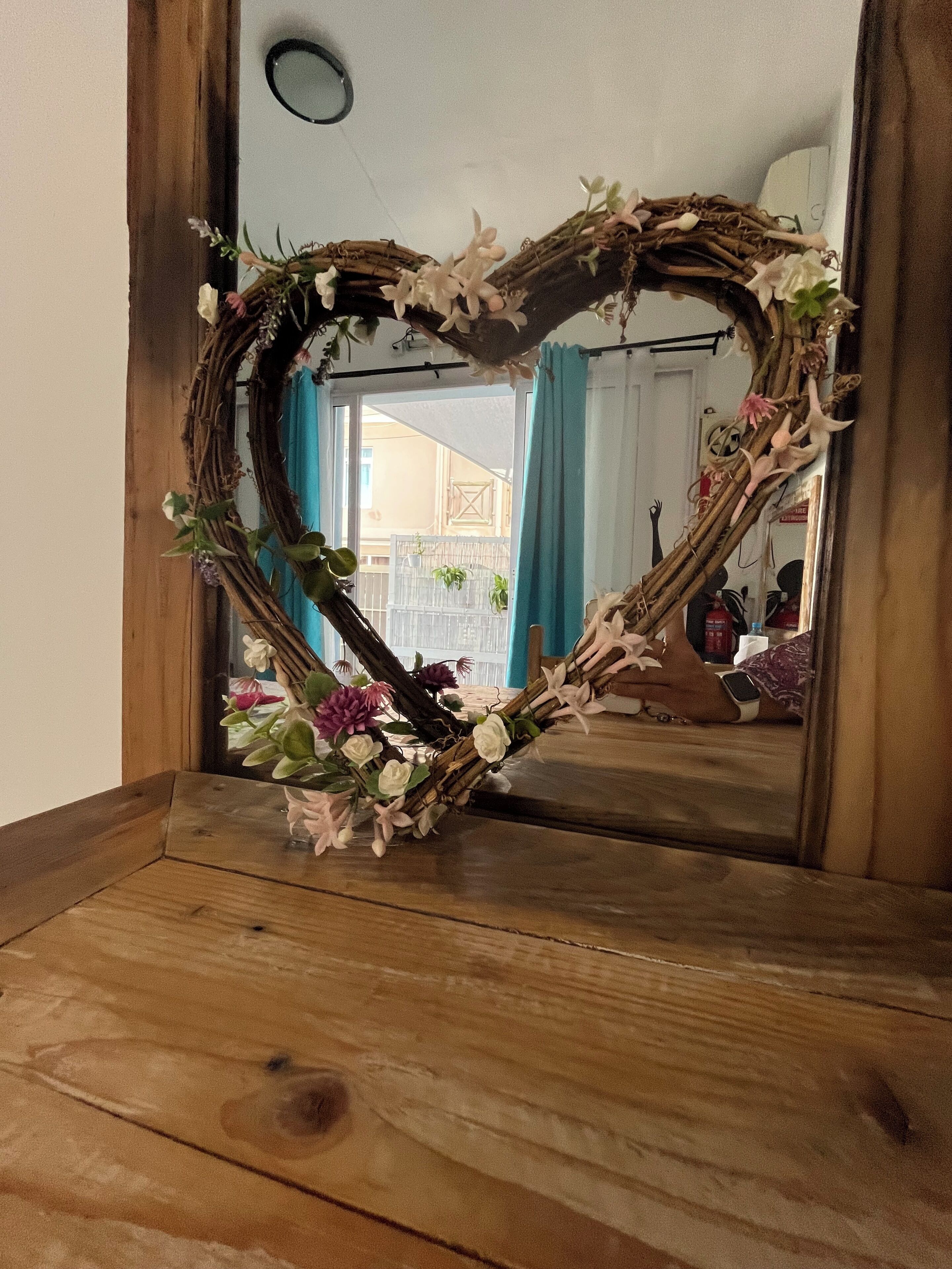 A heart-shaped mirror frame with floral decorations.