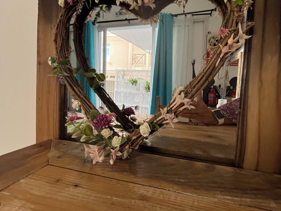 A heart-shaped mirror frame with floral decorations.