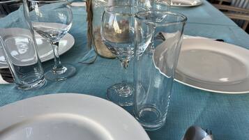 Une table dressée avec de la vaisselle transparente et des assiettes blanches, probablement préparée pour un repas.