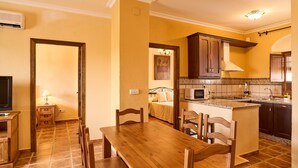 A kitchen with a dining area, a microwave, and a stove. - Apartment 'Amapola' with Balcony, Wi-Fi and Air Conditioning (Valsequillo)