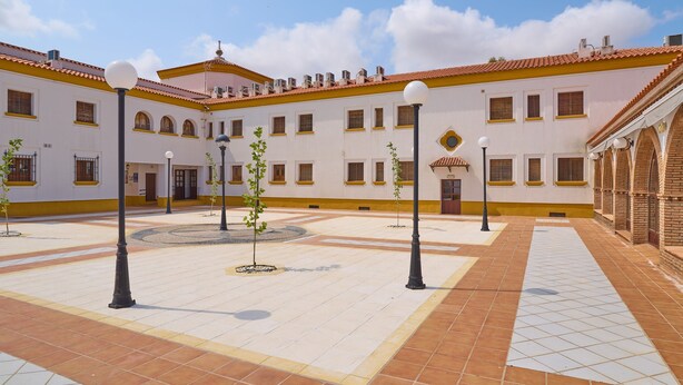 A courtyard with tiled flooring, lamp posts, and a building with multiple windows and a tiled roof. - Apartment 'Amapola' with Balcony, Wi-Fi and Air Conditioning (Valsequillo)