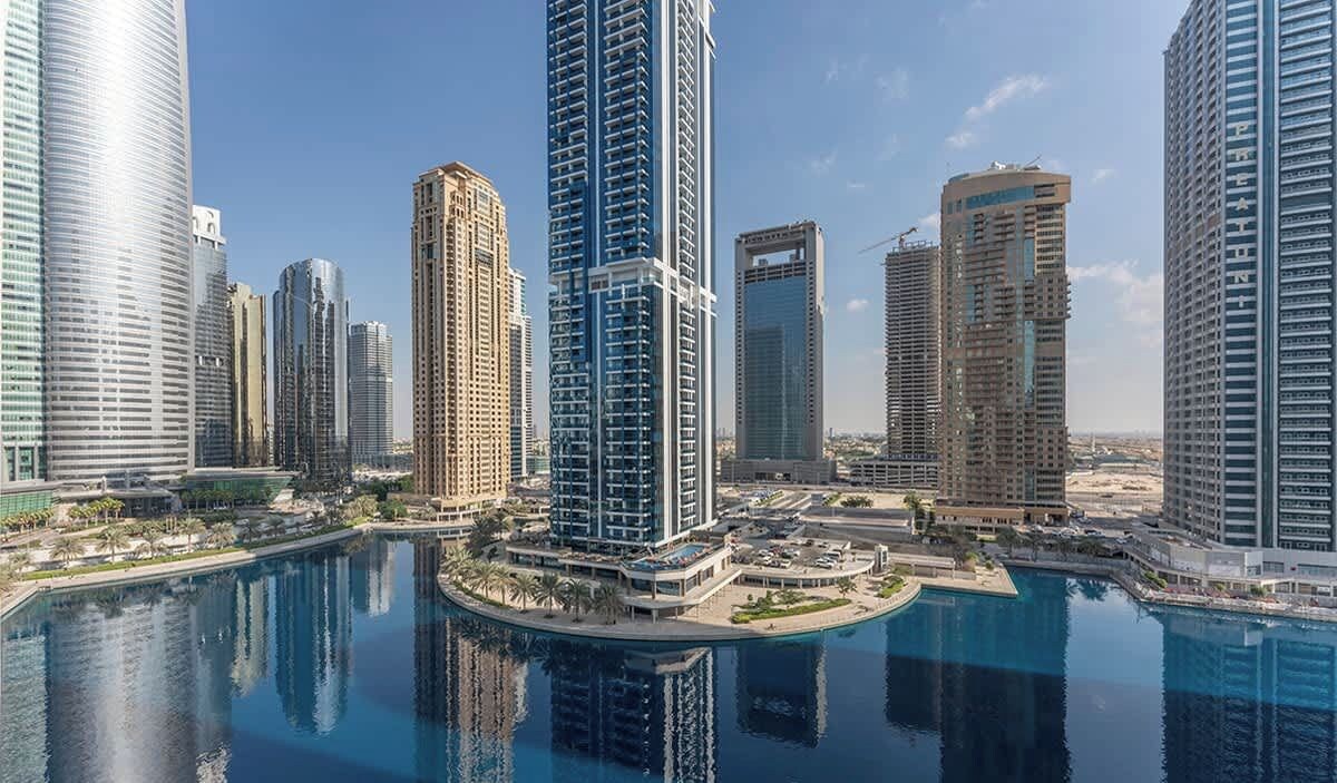 A high-rise urban area with modern skyscrapers and a central circular water feature.