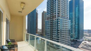 A balcony with a glass railing overlooking high-rise buildings. - Large 1BR with Lake View in JLT  Close to Metro (Dubai)