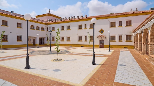 A courtyard with tiled flooring, lamp posts, and a building with multiple windows and a tiled roof. - Apartment 'Jazmin' with Balcony, Wi-Fi and Air Conditioning (Valsequillo)