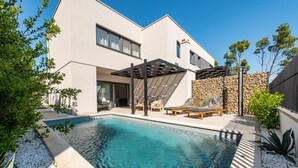A modern house with a swimming pool, outdoor seating, and a stone wall. - Villa Cvita Mia Zadarvillas (Privlaka)