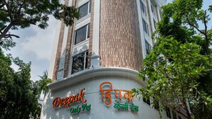 Un edificio con un cartel que indica 'Deepak Only Veg' y 'Nine Square Residency'.