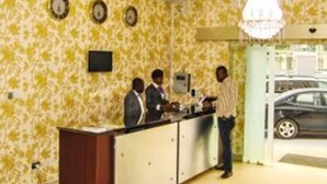 A reception area with a reception desk, a chandelier, and a clock on the wall. - Royal Jatoz Hotel and Suites (Lagos)