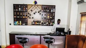 A bar area with a bartender, red and orange chairs, and a brown sofa. - Royal Jatoz Hotel and Suites (Lagos)