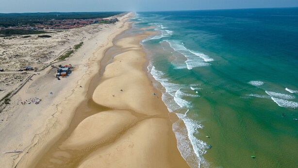 An aerial view of a beach with a long stretch of sand, a few buildings, and a clear view of the ocean. - Spacious 3-bedroom house in Biscarrosse for 6 guests (Biscarrosse)