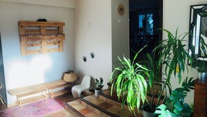 A room with a wooden bench, a white chair, a woven basket, and several potted plants. - Large family villa with shaded terraces, garden and swimming pool (Lédenon)