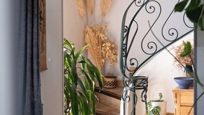A staircase with a wrought iron railing, a wooden bench, and various potted plants. - Large family villa with shaded terraces, garden and swimming pool (Lédenon)