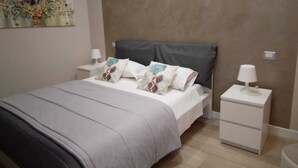 A bedroom with a bed, nightstands, a lamp, and a painting on the wall. - BUNKER DEGLI INVENTORI SRLS (Foggia)