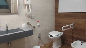 A bathroom with a sink, toilet, bidet, and a mirror. - BUNKER DEGLI INVENTORI SRLS (Foggia)