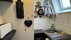 Une cuisine compacte équipée d’un grille-pain, d’un objet décoratif en forme de cœur, d’un égouttoir à vaisselle avec des casseroles et d’un lave-vaisselle.