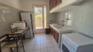 A kitchen with a refrigerator, stove, sink, and cabinets. - Air-conditioned villa with large garden, pets allowed (Palau-del-Vidre)