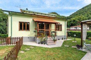 A single-story house with a tiled roof, a front porch, and a staircase leading to the entrance.