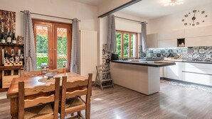 Een moderne keuken met een centraal eiland, een houten eettafel en stoelen.