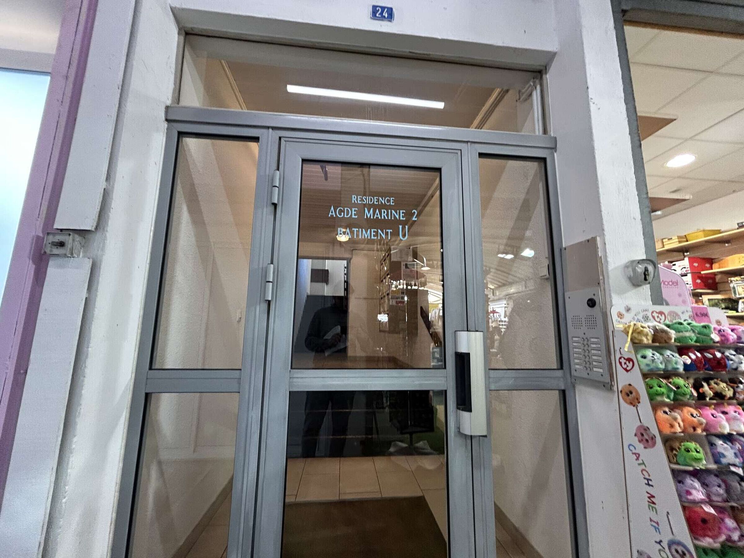 Ingresso di un hotel con una porta in vetro che mostra il nome "Residence AGDE Marine 2" e "Batiment U".