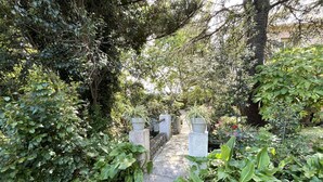 A stone pathway leading through a lush garden with dense foliage and a variety of plants. - Apartment in Furiani near Bastia, 3 bedrooms, pool (Furiani)