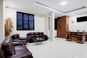 A modern living room with a leather sofa, a coffee table, and a wooden cabinet. - Hotel O Balikpapan near Siloam Hospital formerly Syafla Guest House (Balikpapan)