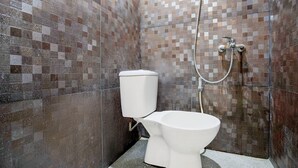 A bathroom with a tiled shower wall, a toilet, and a showerhead. - Hotel O Balikpapan near Siloam Hospital formerly Syafla Guest House (Balikpapan)