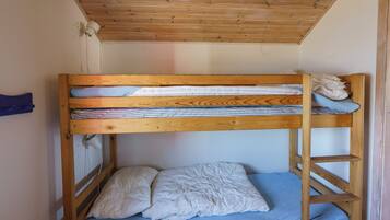 Uma cama beliche com estrutura de madeira, colchão azul e edredom branco.